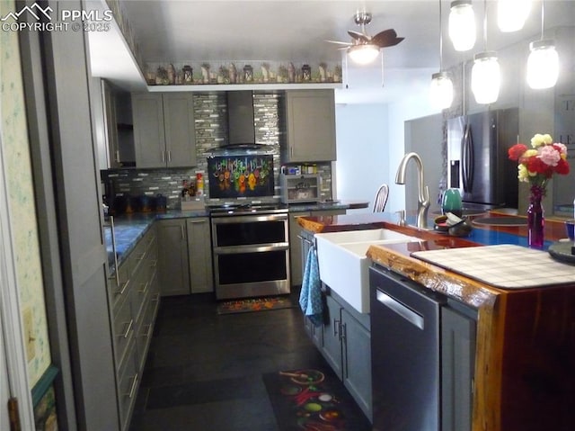 4307 Valli Vista Rd, Colorado Springs, CO 80915 - kitchen featuring appliances with stainless steel finishes, tasteful backsplash, a sink, a ceiling fan, and wall chimney exhaust hood