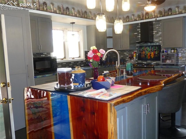 4307 Valli Vista Rd, Colorado Springs, CO 80915 - kitchen with black microwave, tasteful backsplash, wall chimney exhaust hood, and a ceiling fan