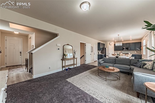 12670 Granite Ridge Dr, Peyton, CO 80831 - living room featuring stairway, a chandelier, and baseboards