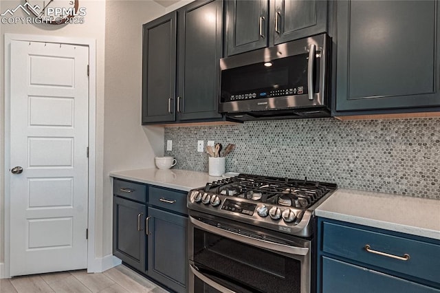12670 Granite Ridge Dr, Peyton, CO 80831 - kitchen with stainless steel appliances, backsplash, light countertops, light wood-style floors, and blue cabinetry