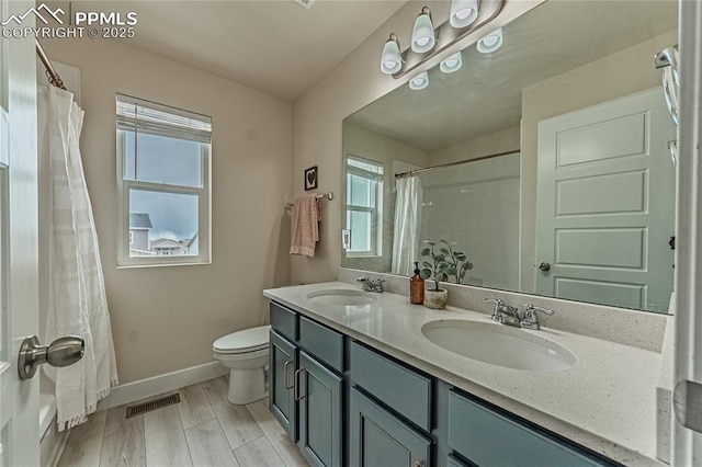 12670 Granite Ridge Dr, Peyton, CO 80831 - full bath with double vanity, baseboards, toilet, and wood finished floors