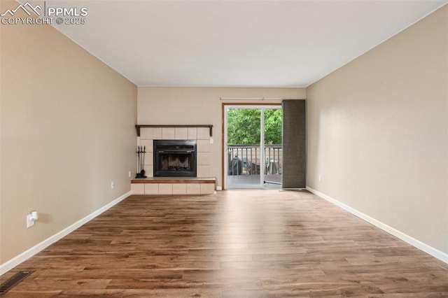 27 Stovel Cir, Colorado Springs, CO 80916 - unfurnished living room featuring wood finished floors, baseboards, and a tiled fireplace