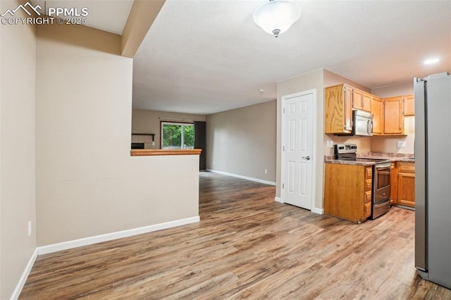 27 Stovel Cir, Colorado Springs, CO 80916 - kitchen featuring appliances with stainless steel finishes, open floor plan, baseboards, and light wood-type flooring