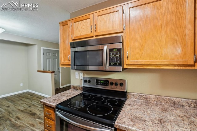 27 Stovel Cir, Colorado Springs, CO 80916 - kitchen featuring stainless steel appliances, dark wood-type flooring, light countertops, and baseboards