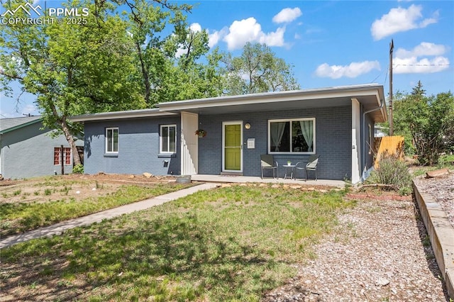 2321 N Meade Ave, Colorado Springs, CO 80907 - ranch-style house with brick siding, a front lawn, and a porch