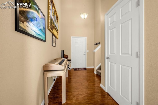 7526 Gallard Hts, Peyton, CO 80831 - corridor with dark wood-style floors, baseboards, stairs, and a high ceiling