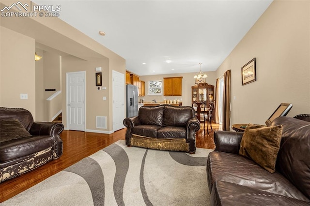 7526 Gallard Hts, Peyton, CO 80831 - living area with wood finished floors, a chandelier, stairs, baseboards, and recessed lighting