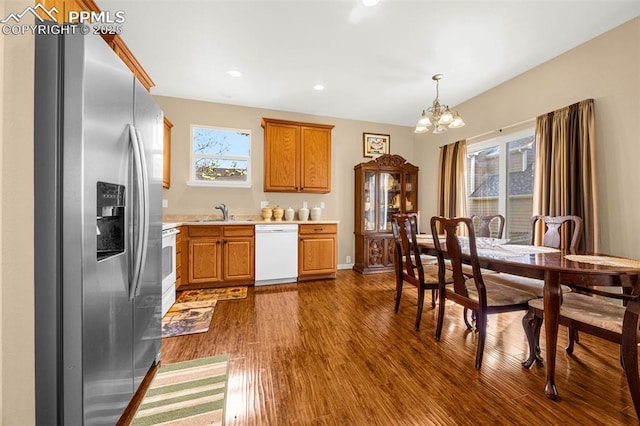 7526 Gallard Hts, Peyton, CO 80831 - kitchen featuring white appliances, a chandelier, light countertops, dark wood-style flooring, and a sink