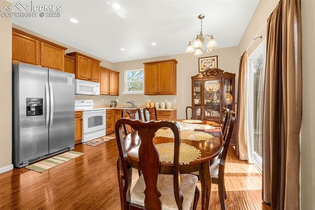 7526 Gallard Hts, Peyton, CO 80831 - dining space featuring wood finished floors, a chandelier, and recessed lighting