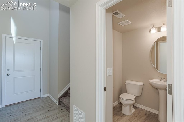 5216 Devers Ct, Colorado Springs, CO 80925 - bathroom featuring wood finished floors, toilet, baseboards, and a sink