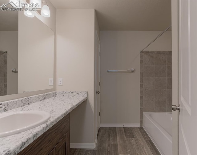 5216 Devers Ct, Colorado Springs, CO 80925 - bathroom with vanity, wood finished floors, baseboards, and bathtub / shower combination