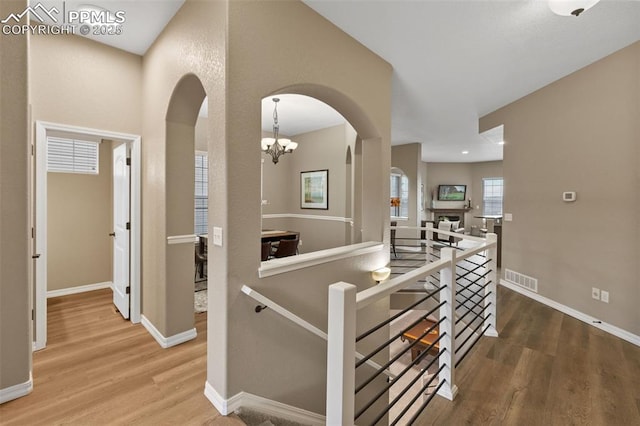 8059 Cinnamon Ct, Colorado Springs, CO 80927 - hall featuring an upstairs landing, arched walkways, wood finished floors, and baseboards