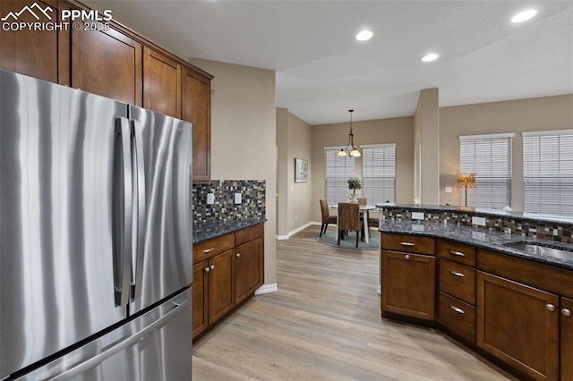 8059 Cinnamon Ct, Colorado Springs, CO 80927 - kitchen with freestanding refrigerator, light wood-type flooring, tasteful backsplash, baseboards, and recessed lighting