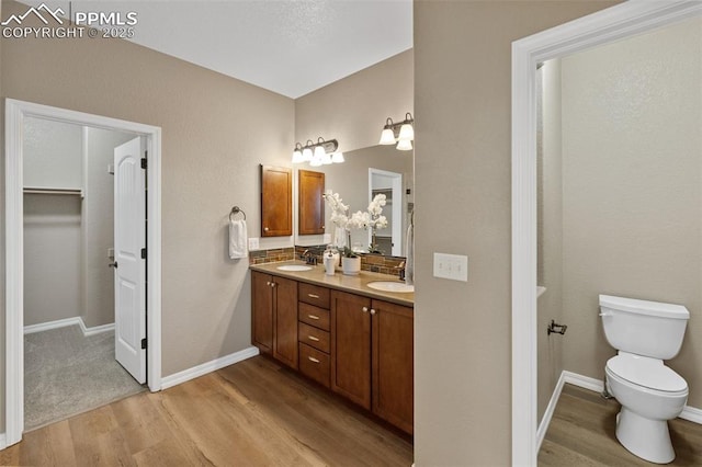 8059 Cinnamon Ct, Colorado Springs, CO 80927 - full bathroom featuring wood finished floors, double vanity, toilet, and baseboards