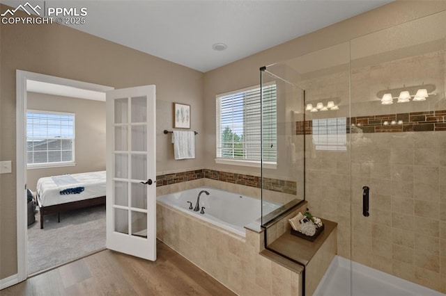 8059 Cinnamon Ct, Colorado Springs, CO 80927 - ensuite bathroom with plenty of natural light, a shower stall, a garden tub, and wood finished floors