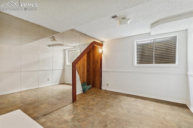 4139 Morley Cir, Colorado Springs, CO 80916 - basement featuring stairs, a textured ceiling, and baseboards