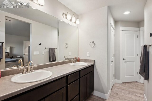 10442 Beckham St, Peyton, CO 80831 - bathroom with double vanity, wood finished floors, baseboards, and ensuite bathroom