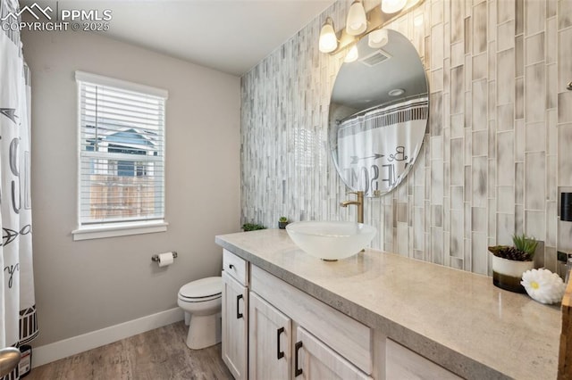10442 Beckham St, Peyton, CO 80831 - full bathroom featuring baseboards, vanity, toilet, wood finished floors, and a shower with shower curtain