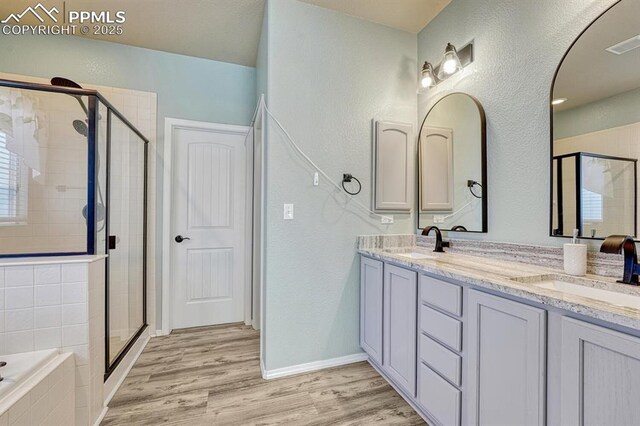 8055 Mount Hayden Dr, Colorado Springs, CO 80924 - full bathroom with a shower stall, double vanity, a bath, wood finished floors, and a textured wall