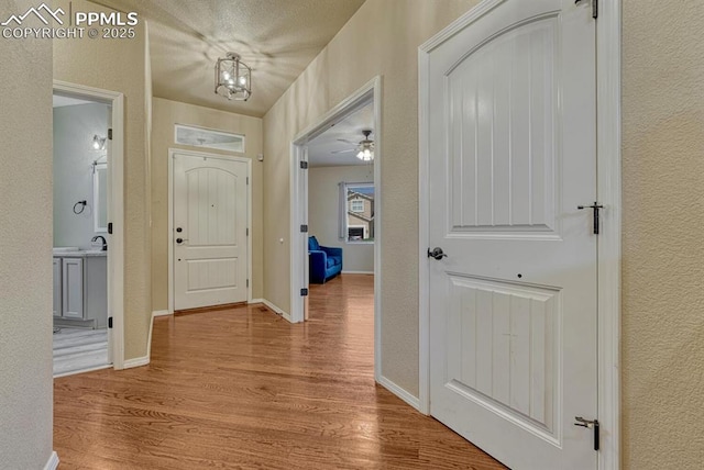 8055 Mount Hayden Dr, Colorado Springs, CO 80924 - entryway featuring wood finished floors, a textured wall, a chandelier, and a ceiling fan
