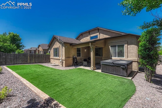8055 Mount Hayden Dr, Colorado Springs, CO 80924 - rear view of house with a hot tub, a fenced backyard, a patio area, and stucco siding
