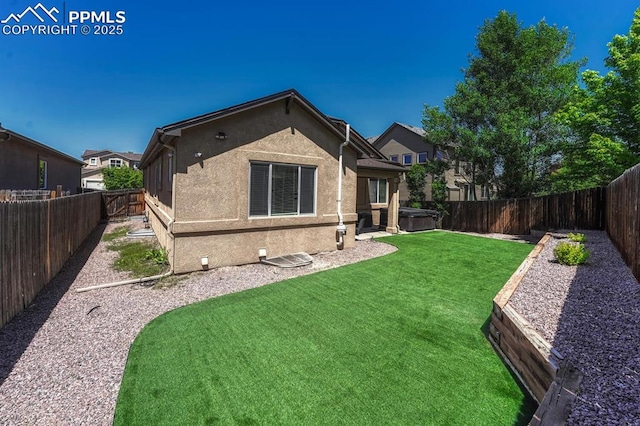 8055 Mount Hayden Dr, Colorado Springs, CO 80924 - rear view of property featuring a hot tub, a fenced backyard, and stucco siding