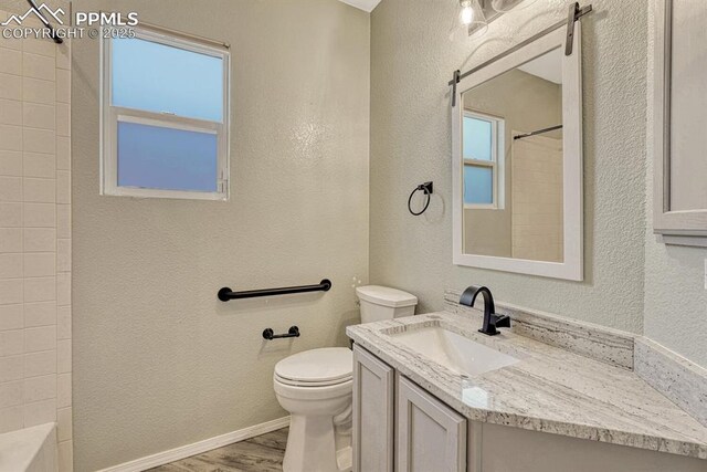 8055 Mount Hayden Dr, Colorado Springs, CO 80924 - full bathroom with a shower, vanity, wood finished floors, plenty of natural light, and a textured wall