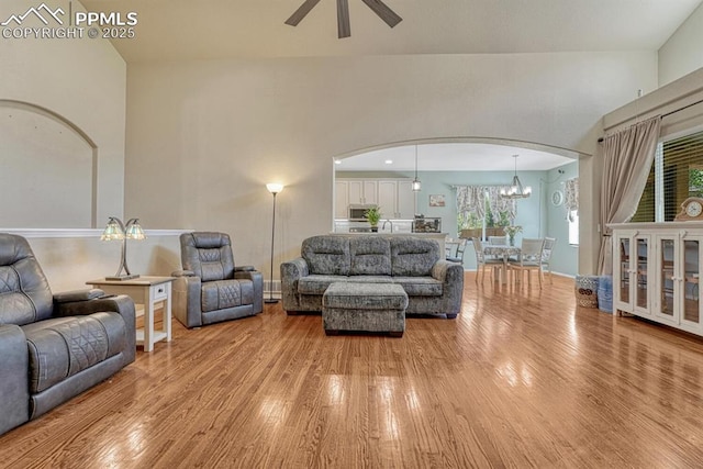 8055 Mount Hayden Dr, Colorado Springs, CO 80924 - living area with arched walkways, light wood finished floors, a ceiling fan, and a chandelier