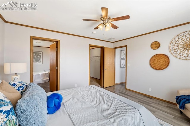 1134 Buffalo Run Rd, Calhan, CO 80808 - bedroom with wood finished floors, ornamental molding, ensuite bathroom, a spacious closet, and baseboards