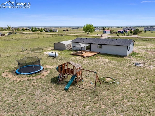 1134 Buffalo Run Rd, Calhan, CO 80808 - view of playground with a trampoline, a deck, a rural view, a yard, and an outdoor structure