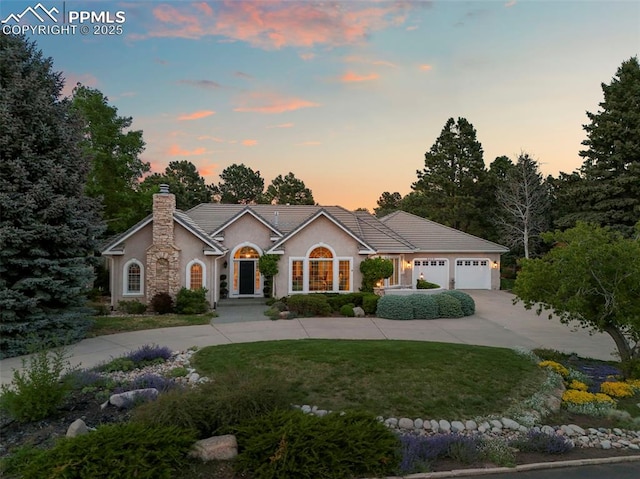 3479 Hill Cir, Colorado Springs, CO 80904 - ranch-style home with curved driveway, stucco siding, a tile roof, a chimney, and a lawn