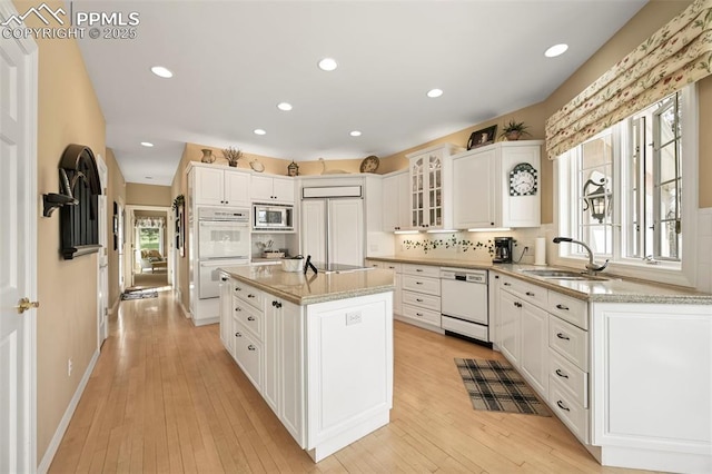 3479 Hill Cir, Colorado Springs, CO 80904 - kitchen with white appliances, glass insert cabinets, white cabinetry, a center island, and backsplash