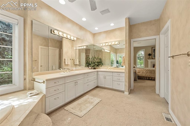 3479 Hill Cir, Colorado Springs, CO 80904 - ensuite bathroom featuring double vanity, a ceiling fan, a tub to relax in, recessed lighting, and a fireplace