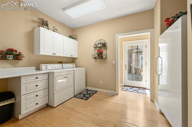 3479 Hill Cir, Colorado Springs, CO 80904 - washroom featuring washing machine and clothes dryer, cabinet space, and light wood-style flooring