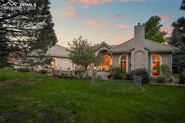 3479 Hill Cir, Colorado Springs, CO 80904 - view of front facade with stucco siding, a chimney, a yard, and a tiled roof