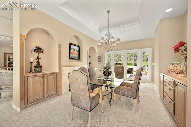 3479 Hill Cir, Colorado Springs, CO 80904 - dining room with light colored carpet, a raised ceiling, a chandelier, ornamental molding, and arched walkways