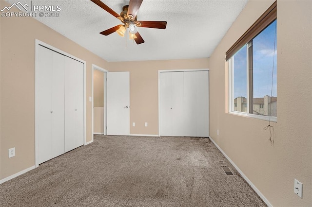 1810 Lanka Ln, Colorado Springs, CO 80915 - unfurnished bedroom featuring two closets, carpet, ceiling fan, a textured ceiling, and baseboards