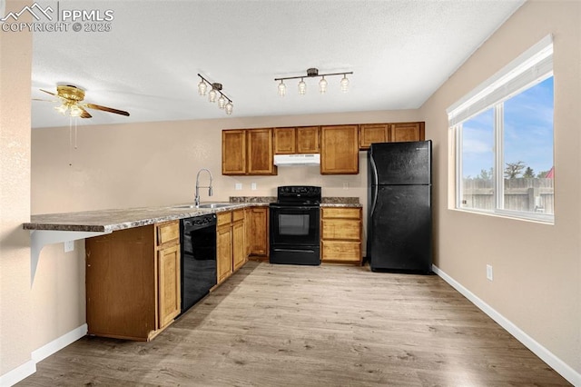 1810 Lanka Ln, Colorado Springs, CO 80915 - kitchen featuring black appliances, under cabinet range hood, a sink, ceiling fan, and light wood finished floors