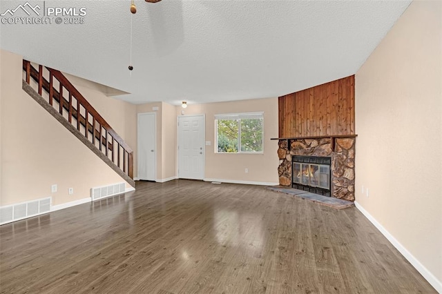 1810 Lanka Ln, Colorado Springs, CO 80915 - unfurnished living room featuring stairway, a fireplace, wood finished floors, baseboards, and a textured ceiling