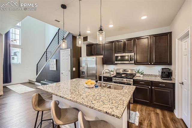 1747 Satin Spar Pt, Colorado Springs, CO 80908 - kitchen featuring appliances with stainless steel finishes, a sink, a kitchen bar, dark brown cabinets, and recessed lighting