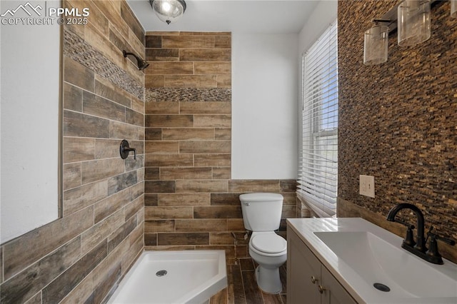 322 Broadway Ave, Pueblo, CO 81004 - bathroom featuring toilet, tile walls, vanity, tiled shower, and wainscoting