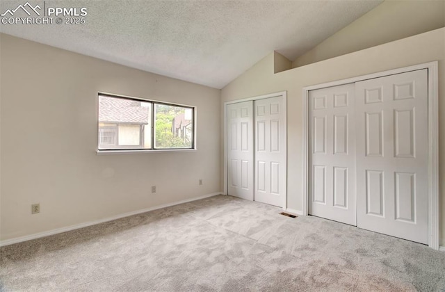 5573 Tamworth Dr, Colorado Springs, CO 80919 - unfurnished bedroom with multiple closets, lofted ceiling, carpet flooring, a textured ceiling, and baseboards
