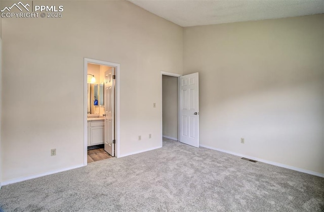 5573 Tamworth Dr, Colorado Springs, CO 80919 - unfurnished bedroom with carpet, a towering ceiling, baseboards, and ensuite bath