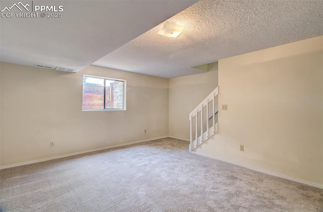 5573 Tamworth Dr, Colorado Springs, CO 80919 - basement featuring carpet, stairway, a textured ceiling, and baseboards