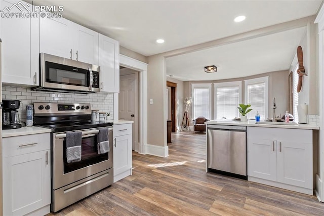 1807 W Colorado Ave, Colorado Springs, CO 80904 - kitchen featuring appliances with stainless steel finishes, a sink, light wood-type flooring, decorative backsplash, and light countertops