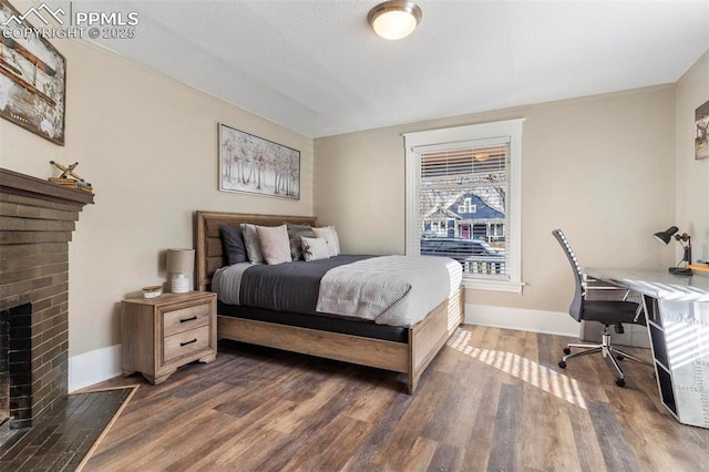 1807 W Colorado Ave, Colorado Springs, CO 80904 - bedroom with wood finished floors, a desk, baseboards, and a brick fireplace