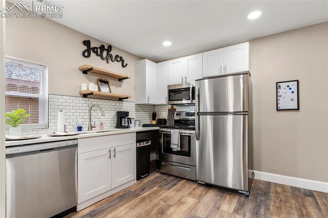 1807 W Colorado Ave, Colorado Springs, CO 80904 - kitchen with appliances with stainless steel finishes, a sink, backsplash, white cabinetry, and light wood finished floors