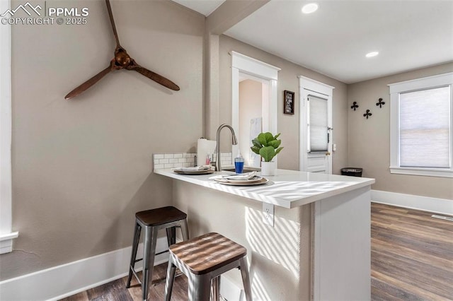 1807 W Colorado Ave, Colorado Springs, CO 80904 - kitchen with dark wood-style floors, a breakfast bar area, baseboards, a peninsula, and recessed lighting