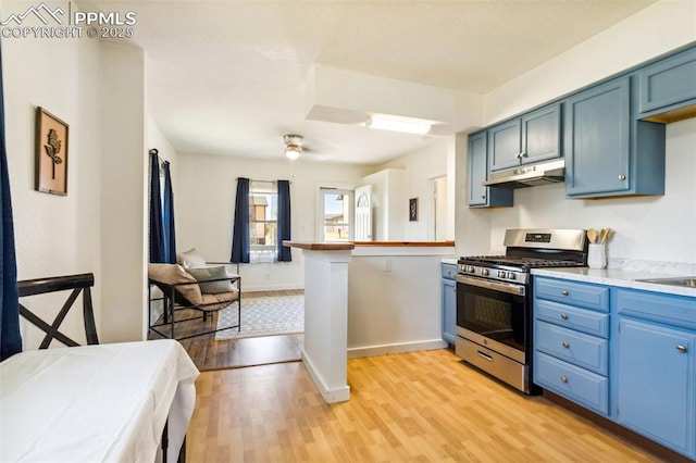 133 W Golden Ave, Cripple Creek, CO 80813 - kitchen featuring stainless steel range with gas stovetop, under cabinet range hood, blue cabinetry, and light wood-type flooring