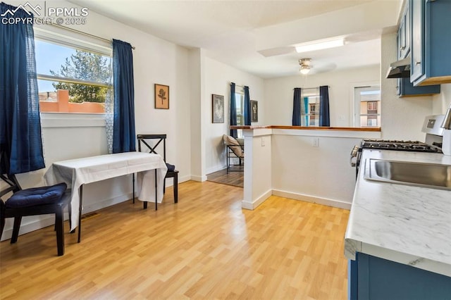 133 W Golden Ave, Cripple Creek, CO 80813 - kitchen featuring light wood-style floors, under cabinet range hood, gas stove, light countertops, and baseboards